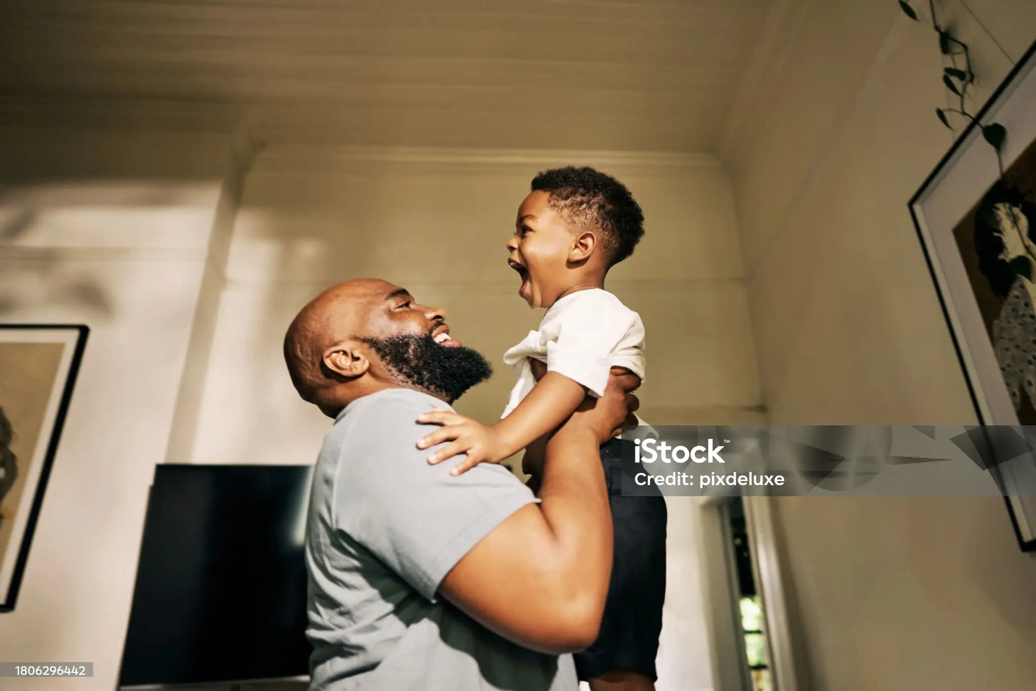 A smiling father playing with his laughing child