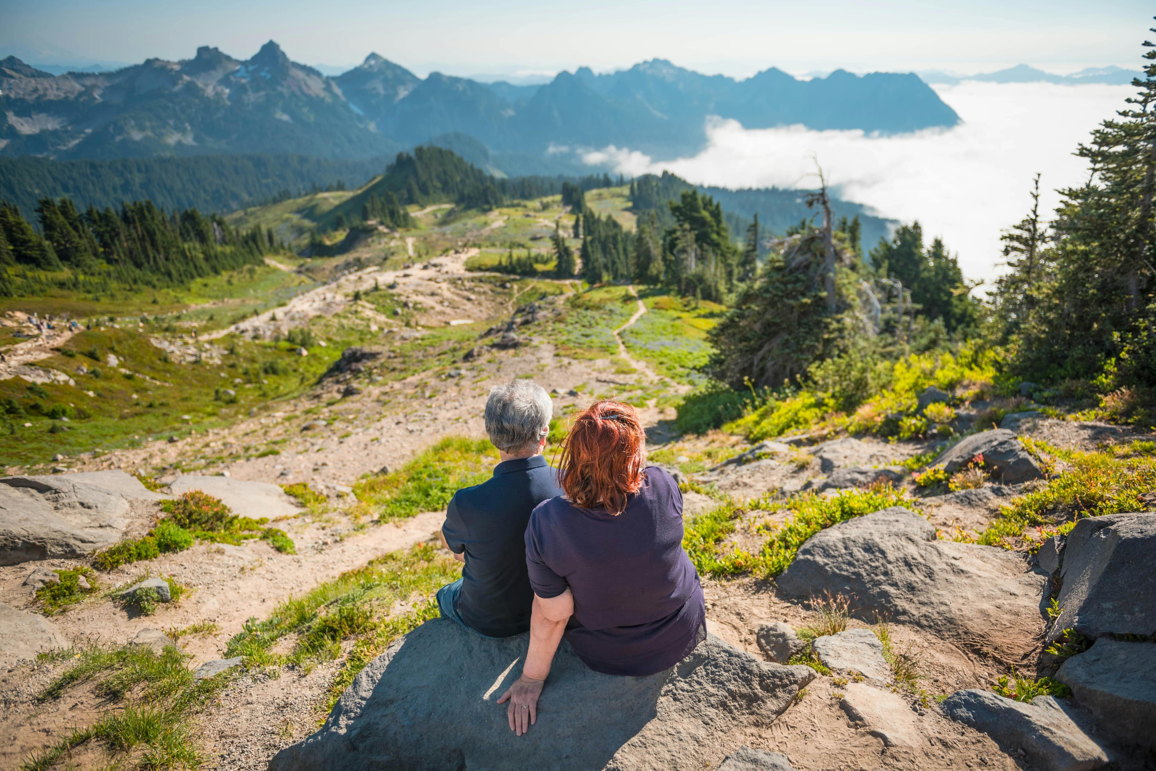 Couple sitting on a mountain looking at scenery
