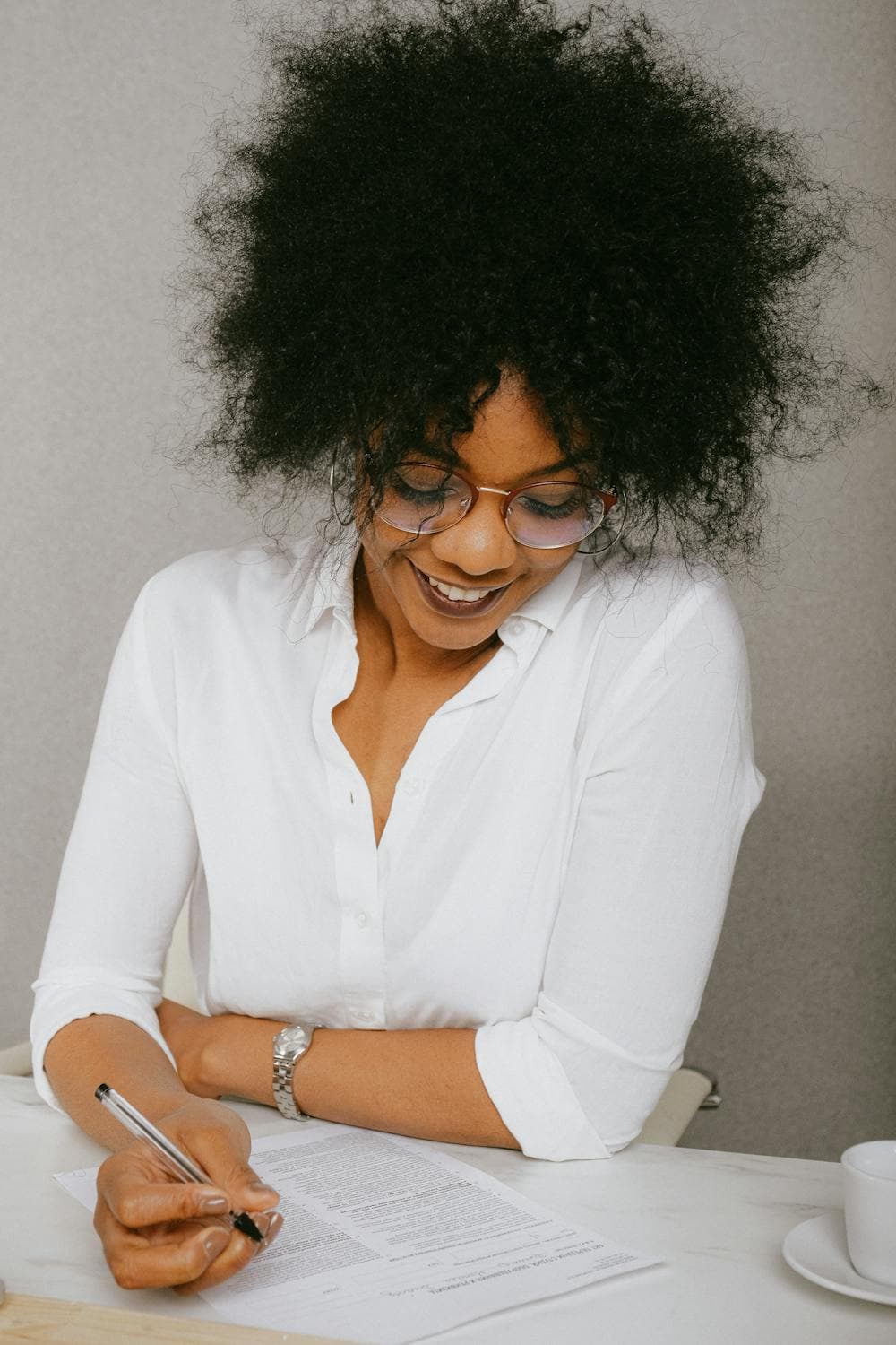 Professional woman smiling while signing documents